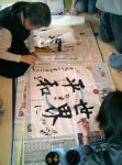 Next we try Japanese caligraphy. The sensei demonstrates drawing kanji with a fudo (brush). The large kanji characters say 